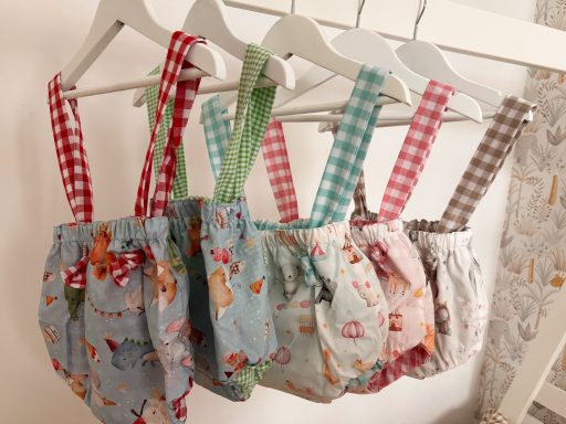 Pantalones cortos de tela con tirantes de diferentes colores y estampados colgados.