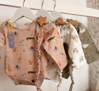 Conjuntos de bodies de bebé con estampados de animales en tonos suaves.